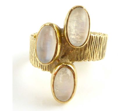 A vintage 1970s 9ct gold ring with three bezel set oval moonstones on a textured band, size N, approx. 6.1g.Condition Report: