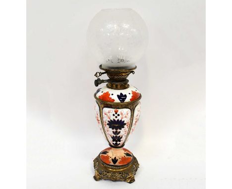 A Victorian ceramic oil lamp decorated in the Imari palette, with modern etched glass shade on a pierced brass base, height 5