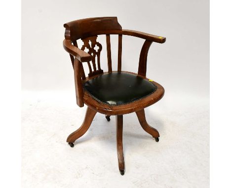 An oak office captain's swivel chair with green leather padded seat.Condition Report: Overall solid but used condition, sligh