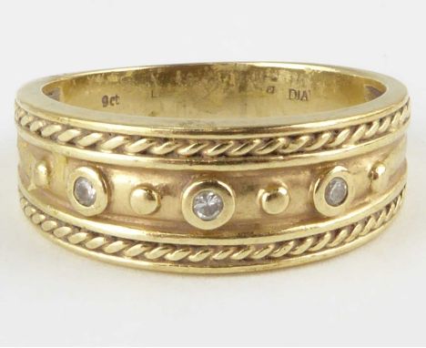 A 9ct gold ring, the top with centred row of three tiny bezel set diamonds flanked by a half hoop rope twist border, size O, 