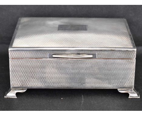 A George VI hallmarked silver desk top cigarette box with engine turned decoration, blank panel to the lid, wood lined, raise