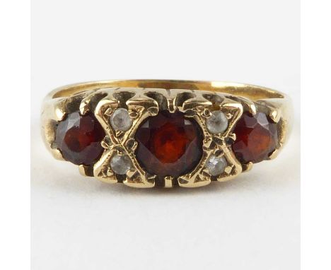 A 9ct gold dress ring set with three graduated garnets separated by two rows of tiny diamonds, size L, approx. 2.3g.