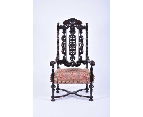 A William and Mary carved walnut open armchairThe crested top rail over carved and pierced splats and turned side rails, the 