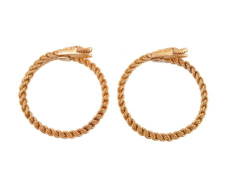 A pair of 1960s gold coloured serpent bangles, the textured heads with ruby eyes, to sprung woven ropetwist bracelet, stamped