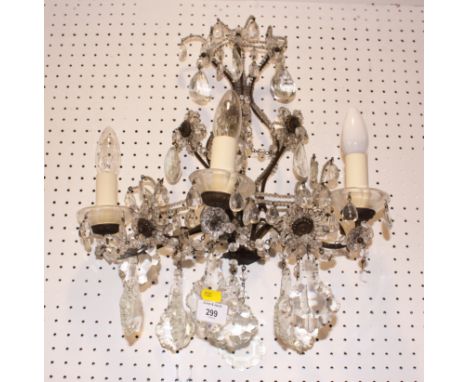 A pair of early 20th century metal framed three-light wall sconces, hung cut glass drops