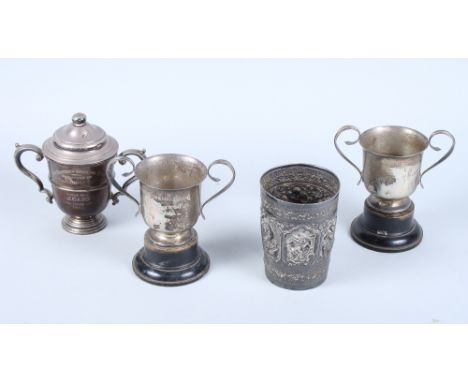 An early 20th century Indian silver beaker, embossed with various figures within a scroll floral border, a silver two-handled