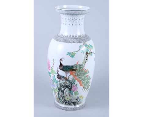 A Chinese Republic period porcelain baluster vase, decorated with peacocks in a flower bush and calligraphy, on circular Gree