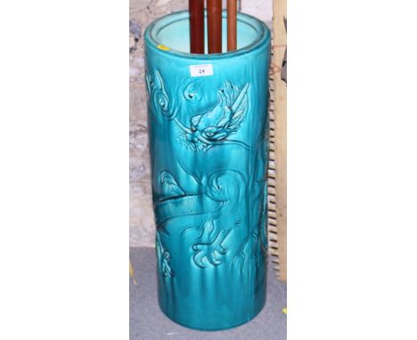 An early 20th century Bretby pottery turquoise glazed cylindrical stick stand with flying dragon decoration, 23 3/4" high