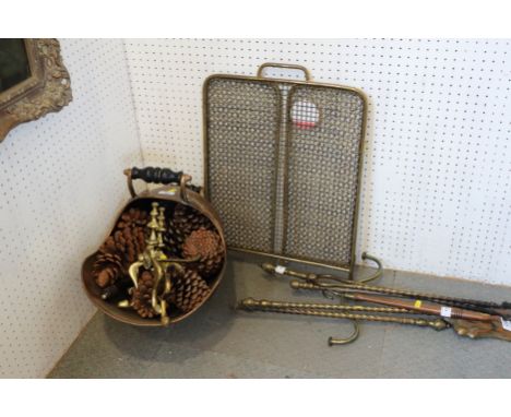 A copper coal helmet, a brass column table lamp, an Edwardian brass wirework fireguard and a set of fire implements and rests