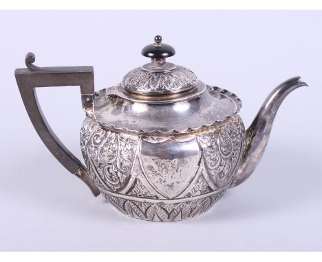 A late Victorian silver teapot with embossed floral and acanthus leaf decoration, composition handle and ebonised knop finial