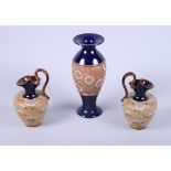 A pair of Royal Doulton Slaters "lacework" stoneware ewers, by Walter Gandy, with "C" scroll