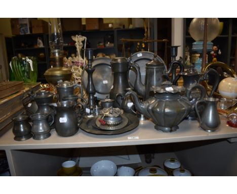 An assorted collection of antique pewter ware, including a Victorian teapot, measures, and an Aladdin oil lamp