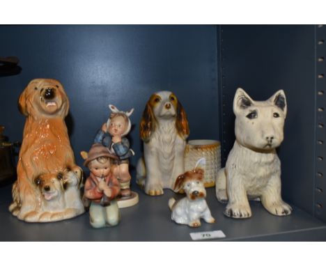 An assorted collection of ceramic and porcelain dog ornaments plus two Goebel Hummel figures