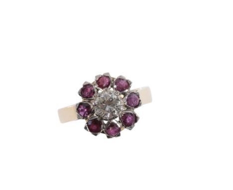 A DIAMOND AND RED SPINEL CLUSTER RING, the brilliant cut diamond, estimated to weigh 0.65 carats, within a surround of circul