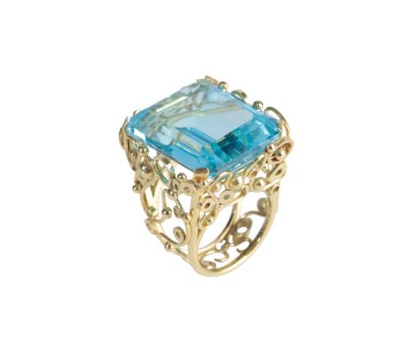 A LARGE RECTANGULAR BLUE TOPAZ DRESS RING, claw-set in an unmarked yellow gold scrollwork double shank, ring size N-O