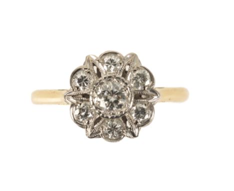 A DIAMOND CLUSTER RING, the central brilliant cut diamond in a millegrain setting, within a surround of brilliant cut diamond