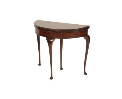 WALNUT DEMI-LUNE CARD TABLE IN GEORGE II STYLE, late 19th/early 20th century, the hinged top with moulded edge, opening to a 