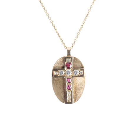 A DIAMOND AND RUBY-SET GOLD CROSS, mounted on a textured gold oval disc, attached to an 18ct yellow gold chain 