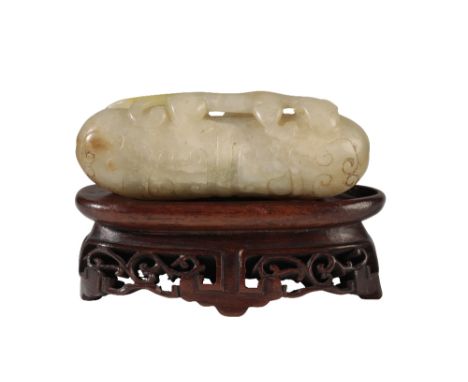 CARVED ARCHAISTIC JADE PENDANT, MING DYNASTY, raised on a craved hardwood base, 7cm long