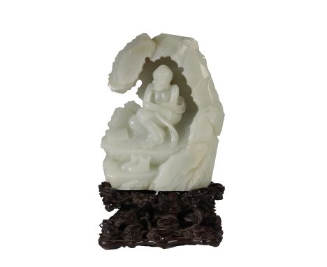 FINE CARVED WHITE JADE GROUP, QING OR LATER, formed as an arhat seated in a grotto, bears inscription, raised ona carved hard