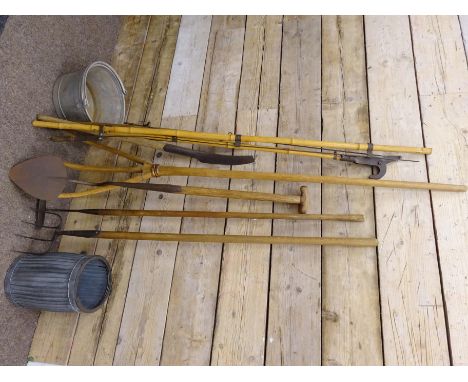 A quantity of vintage garden tools including, a turfing spade, a pitch fork, a hoe, a singletree and bamboo lopper and two me