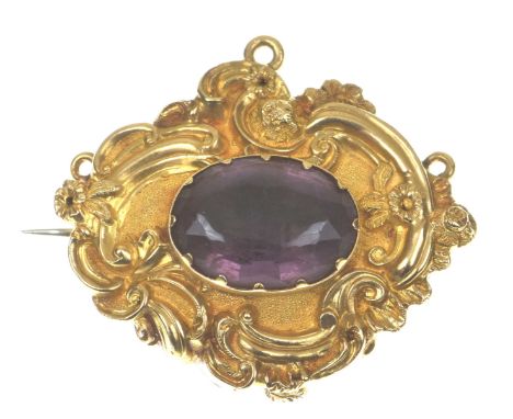A mid 19th Century amethyst conversion broochCentering the closed back oval shape amethyst, within an embossed and chased scr