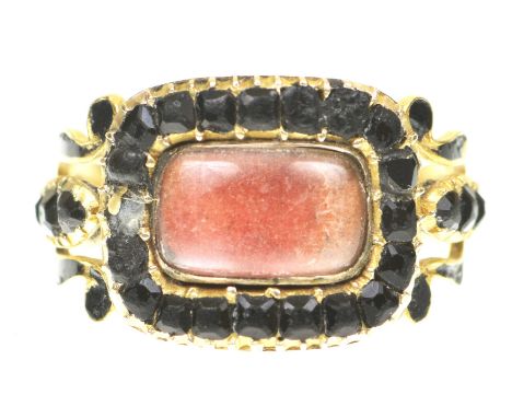 An early 19th Century mourning ringThe vacant central glazed compartment to a faceted black onyx surround, the pierced scroll