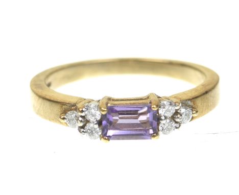 An amethyst and diamond ringCentering a baguette cut amethyst, flanked by clusters of three round brilliant cut diamonds, mod