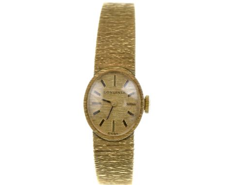 Longines: A ladies 9k gold manual wind bracelet watchThe signed oval textured gold dial, with applied black baton hour marker