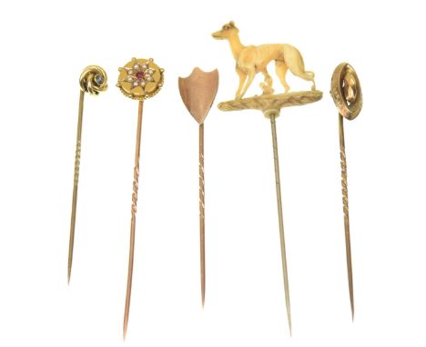 A collection of five late 19th/early 20th Century stick pinsTo include; a carved greyhound stickpin, a rose metal shield stic