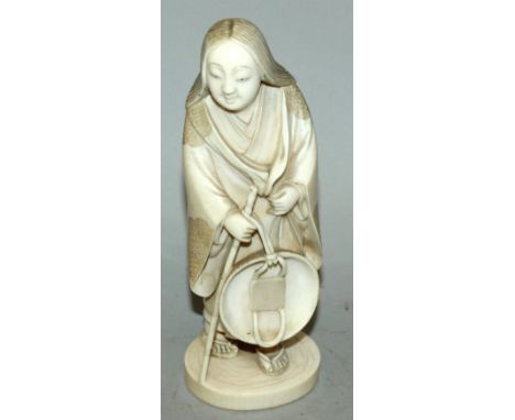 A GOOD QUALITY SIGNED JAPANESE MEIJI PERIOD IVORY OKIMONO OF A STANDING LADY, clasping before her a bamboo stick upon which i