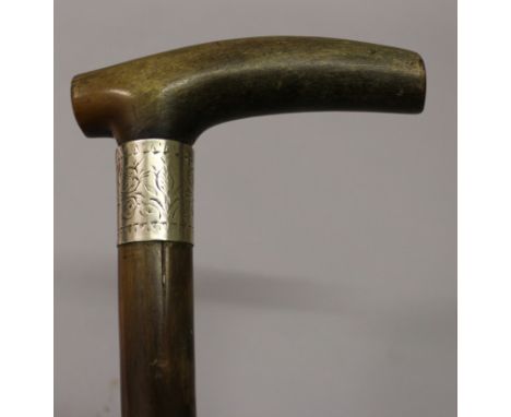 A 19TH CENTURY RHINOCEROS HORN HANDLED WOOD WALKING STICK, with an engraved silver-metal collar, the yellowish-amber horn wit