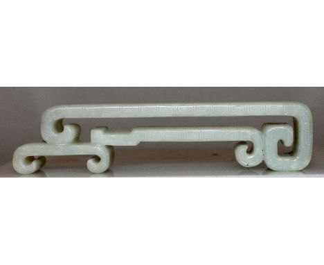 AN UNUSUAL CHINESE CELADON JADE STAND, the pierced two-tier form with scroll ends and key-fret engraving to the rims, 4.5in w