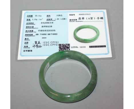 A CHINESE GREEN JADE BANGLE, together with a certificate, the bangle 2.8in diameter, the inner rim 2.2in diameter.