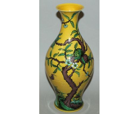 A CHINESE YELLOW GROUND PORCELAIN VASE, decorated with bats and a peach tree, the base with a six-character Kangxi mark, 11.5