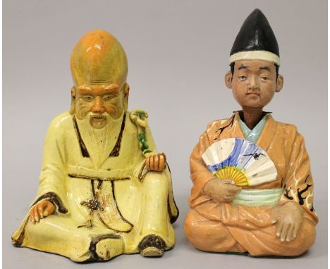 TWO 20TH CENTURY JAPANESE GLAZED CERAMIC SEATED FIGURES, one of Fukurokuju, the other of a man with a fan and a nodding head,