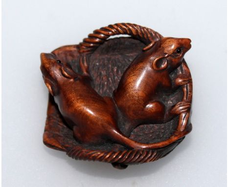 A 19TH/20TH CENTURY SIGNED JAPANESE WOOD NETSUKE OF TWO RATS IN A BASKET, the eyes of each animal inlaid, the base with a sma