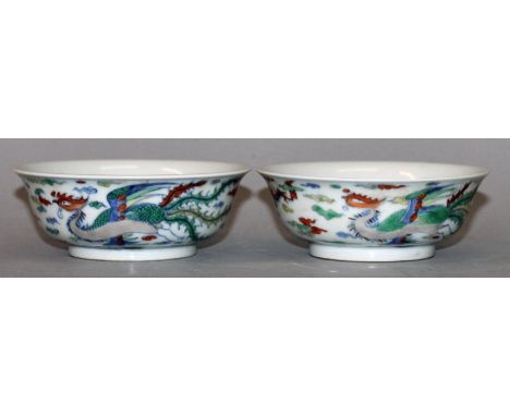 A SMALL PAIR OF CHINESE DOUCAI PORCELAIN DRAGON & PHOENIX BOWLS, each base with a six-character Kangxi mark, each 4.6in diame