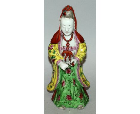 AN EARLY 19TH CENTURY CHINESE JIAQING/DAOGUANG PERIOD PORCELAIN FIGURE OF GUANYIN, circa 1820, dressed in floral decorated ro