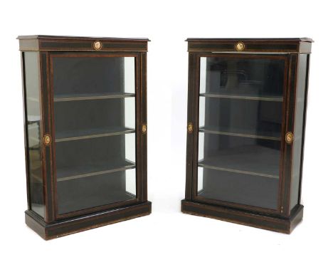 A pair of ebony and amboyna pier cabinets,late 19th century, each moulded rectangular top above a glazed door surrounded by p