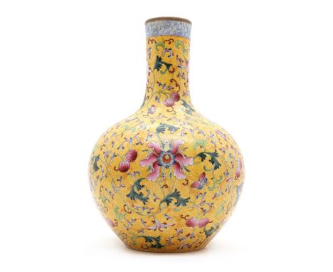 A porcelain bottle vase, late 20th century, Chinese, painted in enamels with peonies and scrolls to a yellow ground, bearing 