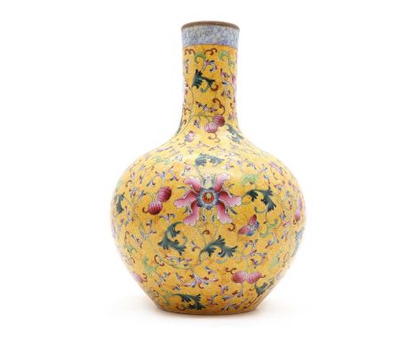 A porcelain bottle vase, late 20th century, Chinese, painted in enamels with peonies and scrolls to a yellow ground, bearing 