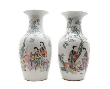 A pair of Chinese qianjiang enamelled vases, 20th century, of baluster form with a flared mouth, painted with ladies and boys