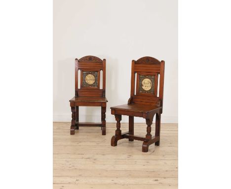 A pair of Aesthetic walnut hall chairs,each centred to the back with a John Moyr Smith pottery tile, depicting scything or re