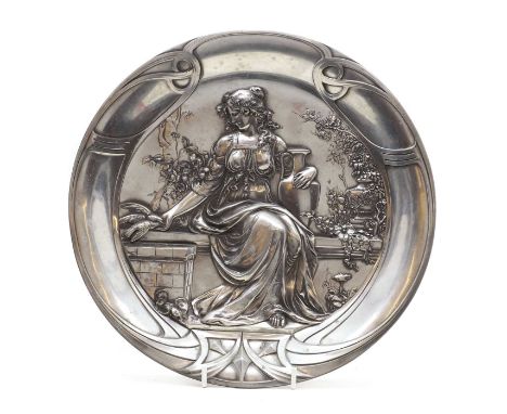 A WMF pewter dish, of circular form depicting a classical maiden seated on a bench feeding doves, cast '281A' and stamped mar