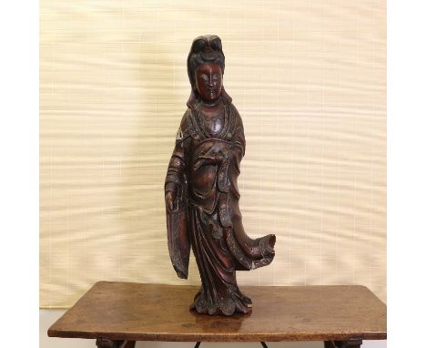 A Chinese lacquered wood guanyin, early 20th century, wearing a long floating robe with floral borders, with a scroll in the 