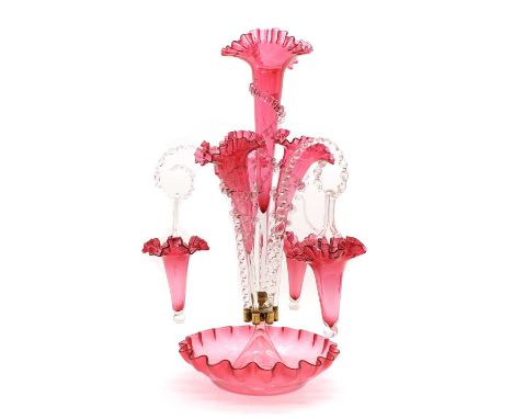 A Victorian cranberry glass epergnecirca 1880, the central trumpet with trailing decoration, enclosed by three smaller trumpe
