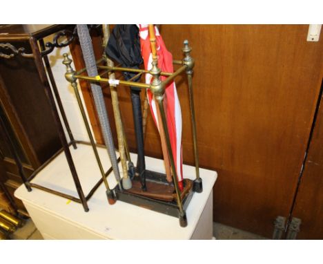 A brass six division stick stand with umbrellas and walking sticks 