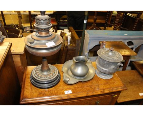 A Tudric pewter dish; a pewter tea pot and jug; and an oil lamp base 