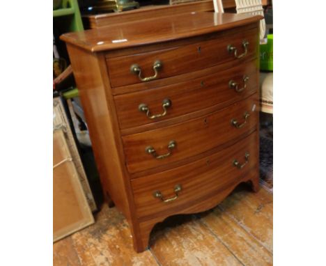 Mahogany bow-fronted chest of four drawers with brass handles on four bracket feet